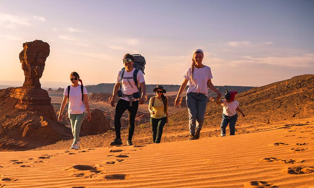 Tourist family walking through the sand dunes in Mongolia